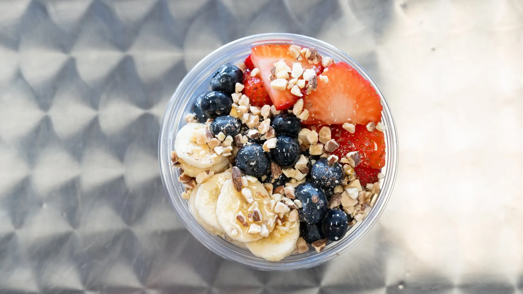 An acai bowl topped with fresh fruit and granola